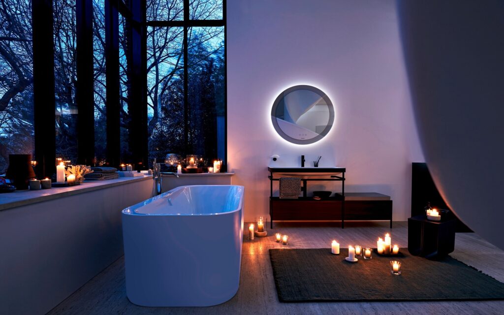 Duravit bathroom mirror provides gentle lighting next to free standing bath